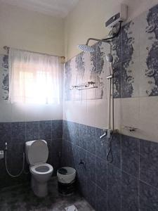 a bathroom with a toilet and a shower at G & S Executive Lodge in Dar es Salaam