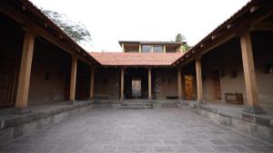ein leerer Innenhof eines Gebäudes mit rotem Dach in der Unterkunft Nisarg Resort in Kolhapur