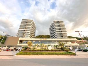 dois altos edifícios brancos com palmeiras à frente deles em Ark Seaview Holiday Inn em Sihanoukville