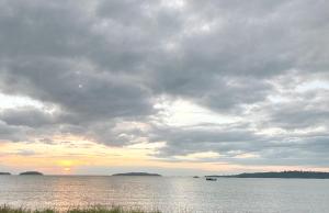 un cielo nublado sobre un cuerpo de agua con un barco en Ark Seaview Holiday Inn, en Sihanoukville