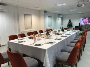 une grande salle de conférence avec une grande table et des chaises dans l'établissement Birlik, à Tengiz