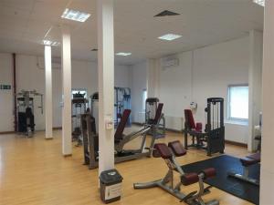 a gym with several treadmills and machines in a room at Birlik in Tengiz