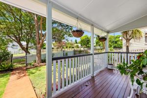 a screened porch with a white roof and a wooden deck at Ambiente Cottage - Pet and Family Friendly in Toowoomba