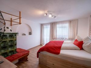 a bedroom with a large bed with a red blanket at Ferienwohnung Emmerenzia in Söll