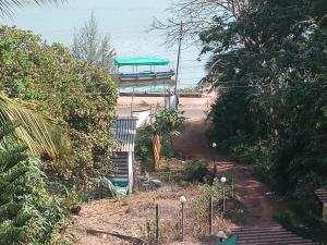 une maison avec un bateau sur une route arborée dans l'établissement Govindaashram, à Bhogwe