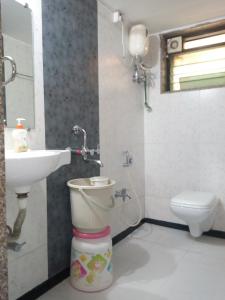 La salle de bains est pourvue de toilettes et d'un lavabo. dans l'établissement Govindaashram, à Bhogwe
