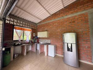 een keuken met een bakstenen muur en een koelkast bij Condominio la laguna in La Rochela