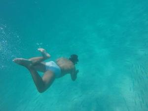 Eine Frau, die im Meer schwimmt in der Unterkunft Areia Branca Casas / casa 1. in Cabo Frio
