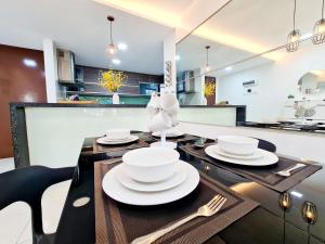 eine Küche mit einem Tisch und weißen Gerichten darauf in der Unterkunft 7 Guest Chill 3 Room Koi Kinrara Suite, IOI Puchong, Bukit Jalil Pavilion, Bukit Jalil Stadium, Sunway Pyramid, Sunway Lagoon in Kampong Baharu Sungai Way