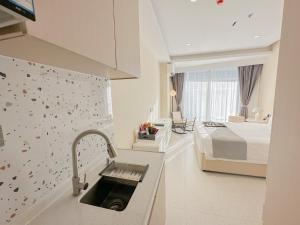 uma cozinha com um lavatório num quarto com uma cama em Ark Seaview Holiday Inn em Sihanoukville