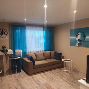 ein Wohnzimmer mit Sofa und blauen Vorhängen in der Unterkunft Trinitix apartment in Tapa