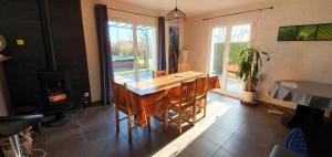 - une cuisine avec une table en bois et un poêle à bois dans l'établissement Villa du pic vert 105m2 , 4 chambres de plain-pied avec piscine à Montfaucon, à Montfaucon