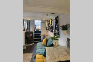 a living room with a couch and a table at Narrow Boat moored in London in London