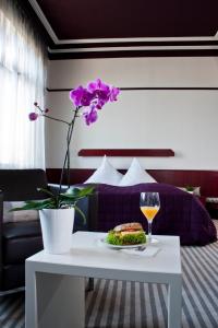 a table with a plate of food and a glass of wine at Hotel Neuer Karlshof in Baden-Baden