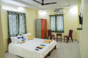 a room with a bed and some chairs and curtains at Hotel Yellow Bells in Hyderabad