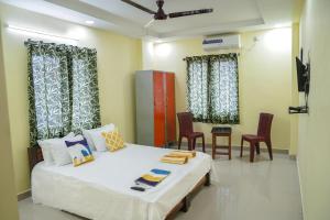 Zimmer mit einem Bett und einigen Stühlen und Vorhängen in der Unterkunft Hotel Yellow Bells in Hyderabad