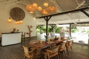een eetkamer met een grote houten tafel en stoelen bij Villa Tabatha by Optimum Bali Villas in Seminyak