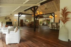 salon z białymi meblami i drewnianą podłogą w obiekcie Villa Tabatha by Optimum Bali Villas w mieście Seminyak