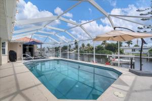 - une piscine avec un auvent et un parasol dans l'établissement 3 BR Private Vacation Home, à Punta Gorda