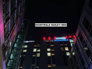 a night view of a skyscraper with a sign for shootaughaughaugh mask at Air Residence a2 @Central RCBC/Canadian Embassy in Manila