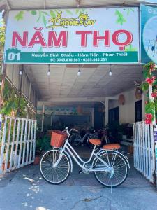 ein Fahrrad, das vor einem nam tin shop geparkt ist in der Unterkunft N'T Homestay in Mui Ne