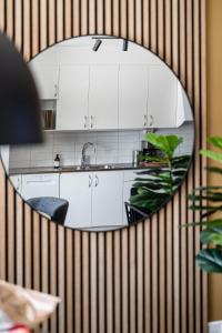 a mirror reflecting a kitchen with white cabinets at Elite Business Suite in Nyköping
