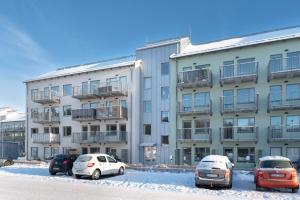 a building with cars parked in a parking lot at Elite Business Suite in Nyköping