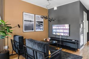 a living room with two chairs and a tv at Elite Business Suite in Nyköping