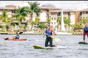 a woman on a paddle board in the water at Dayuse em luxuoso resort - NÃO INCLUI QUARTO in Brasilia