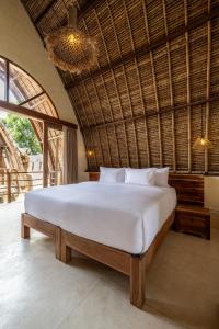 um quarto com uma grande cama branca num quarto em Lulu's Villas em Uluwatu