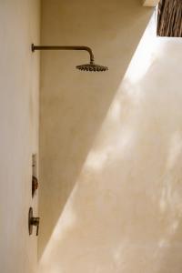 a shower in a bathroom with a white wall at Lulu's Villas in Uluwatu