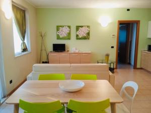 a dining room with a table and green chairs at Residenza Villa in Corno Alto
