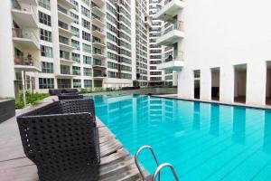 a swimming pool with chairs next to a building at 6 Pax Regalia Suite & Residences Infinity Pool with KL City View in Kuala Lumpur