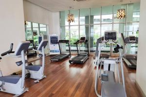 a gym with several treadmills and exercise bikes at 6 Pax Regalia Suite & Residences - Infinity Pool with KL City View in Kuala Lumpur