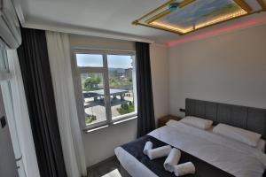 1 dormitorio con cama y ventana grande en Black Pearly Hotel en Trebisonda