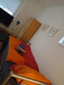 a bedroom with a bed with an orange blanket at Stellas Monteurs u. Ferienwohnung in Mülsen