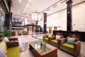 a lobby with couches and tables in a building at CH Hotel in Chiang Mai