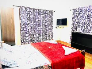 a bedroom with a bed with a red blanket at Sahyadri Homestay wayanad in Kalpetta