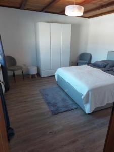 a bedroom with a white bed and two chairs at Ferienhaus Frankenmarkt in Frankenmarkt