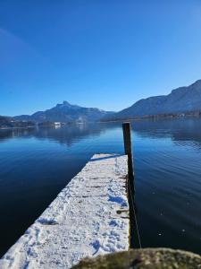 a dock on a lake with snow on the water at Ferienhaus Frankenmarkt in Frankenmarkt