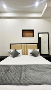 um quarto com uma grande cama branca e 2 almofadas em Dhaneshwari Homestay em Varanasi