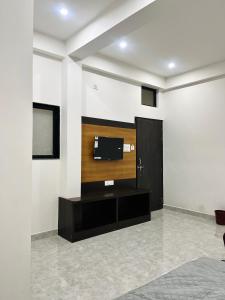 a living room with a tv on a wall at Dhaneshwari Homestay in Varanasi