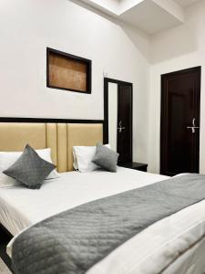 a bedroom with a large white bed with two pillows at Dhaneshwari Homestay in Varanasi