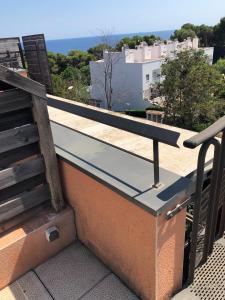 um banco no topo de um edifício numa varanda em Sunny apartment Sa Boadella big solarium sea view em Lloret de Mar