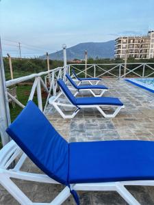 een groep blauwe ligstoelen op een patio bij THE AVID HOTEL in Voi