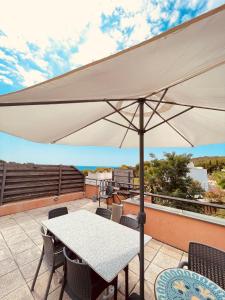 a white umbrella on a patio with a table and chairs at Sunny apartment Sa Boadella big solarium sea view in Lloret de Mar