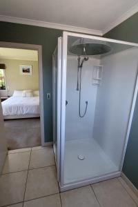 a bathroom with a shower and a bed in a room at Private guest room - no kitchen in Wanaka