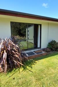 a house with a large glass door in a yard at Private guest room - no kitchen in Wanaka