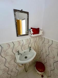 La salle de bains est pourvue d'un lavabo, de toilettes et d'un miroir. dans l'établissement natures homestay, à Khajurâho