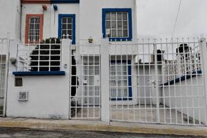 una cerca blanca frente a una casa blanca en Casa Cuarzo Mineral de la Reforma, en Pachuca de Soto
